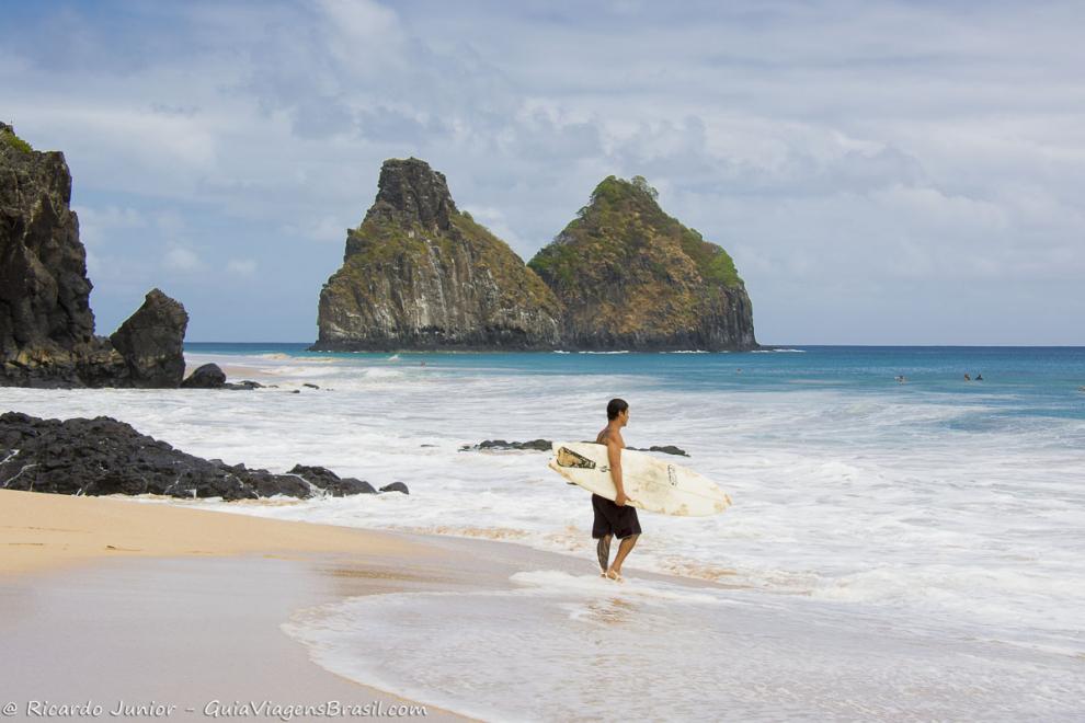 Imagem de um surfista na beira da Praia Cacimba do Padre.
